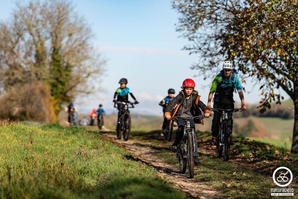 Groupe de jeunes vététistes en randonnée sur un sentier ensoleillé